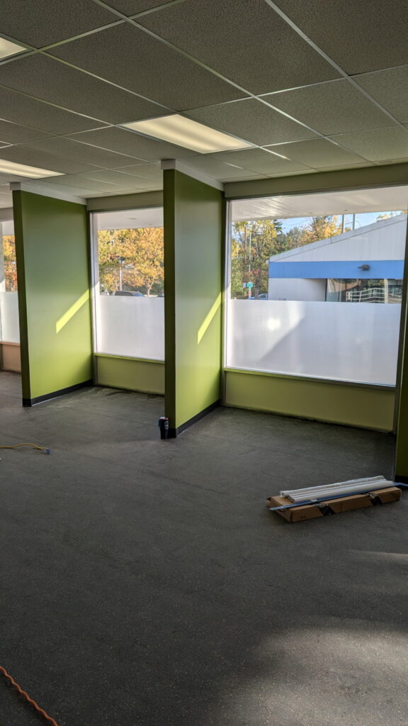 Walls painted green and large windows with privacy film