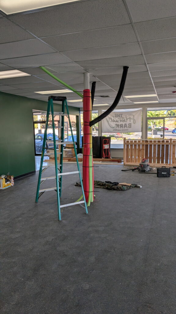 Indoor dog park with a tree being built out of foam and piping